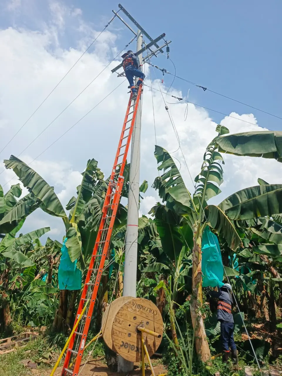 Instalación de infraestructura para redes eléctricas aéreas con postes, crucetas y tendido de conductores de media tensión en zona exterior.